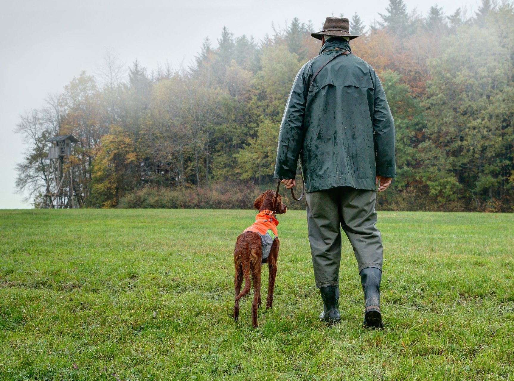 Ein Jäger spaziert mit seinem Hund.