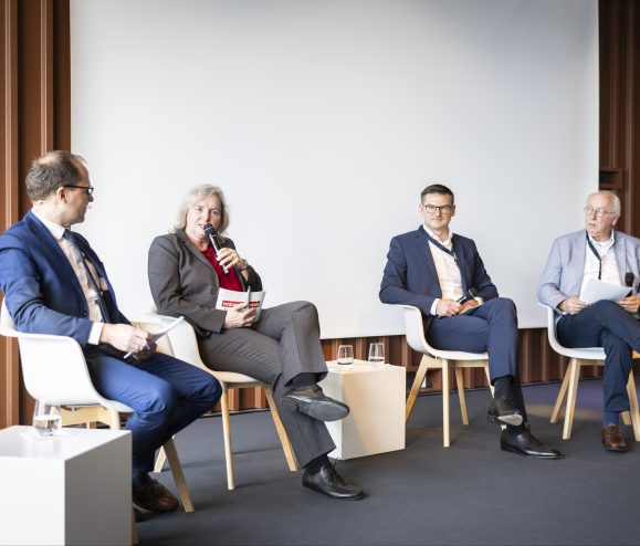 Vier Personen sitzen in einer Diskussionsrunde.