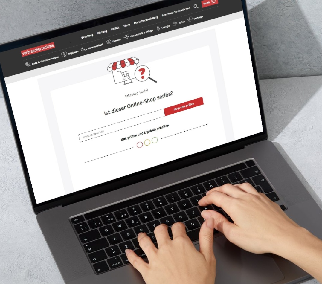 Hände auf einer Laptop-Tastatur, auf dem Bildschirm wird die Website der Verbraucherzentrale mit dem Fakeshop-Finder angezeigt, der die Seriosität von Online-Shops überprüft.
