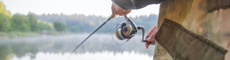 Ein Angler hält seine Angel ins Wasser.