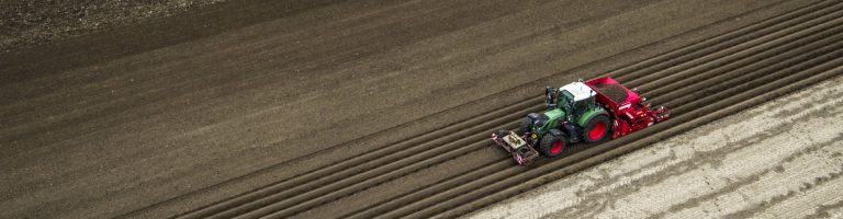 Ein landwirtschaftliches Fahrzeug bearbeitet ein Feld.