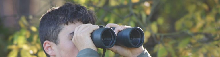 Eine Person guckt durch ein Fernglas.